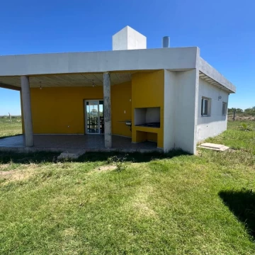 Casa en alquiler – Predio cerrado sobre Ruta 18  Se alquila casa funcional en predio cerrado, ubicada sobre Ruta 18, ideal para quienes buscan seguridad, tranquilidad y fácil acceso a la ciudad.  Características de la propiedad:  2 dormitorios  Cocina comedor y living integrados  1 baño completo  Amplio espacio verde dentro del predio, ideal para disfrutar al aire libre, reuniones o actividades recreativas  El predio cerrado ofrece seguridad, privacidad y un entorno cuidado, combinando comodidad con un acceso estratégico sobre la Ruta 18.  