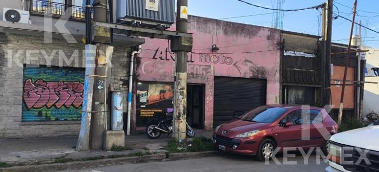 Fachada exterior del local – Cortina metálica y acceso vehicular sobre Calle 27