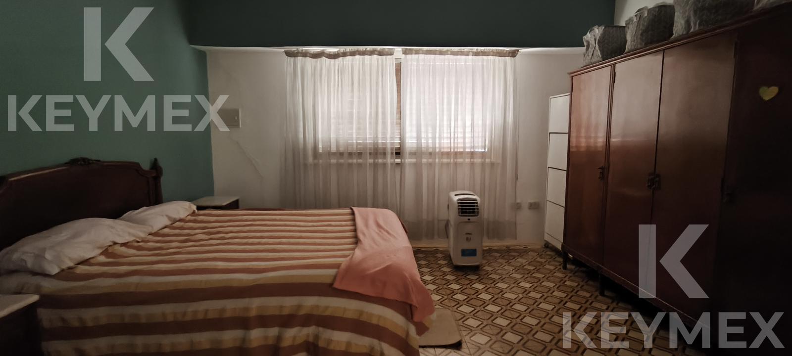 Dormitorio con placard y ventana al jardín trasero