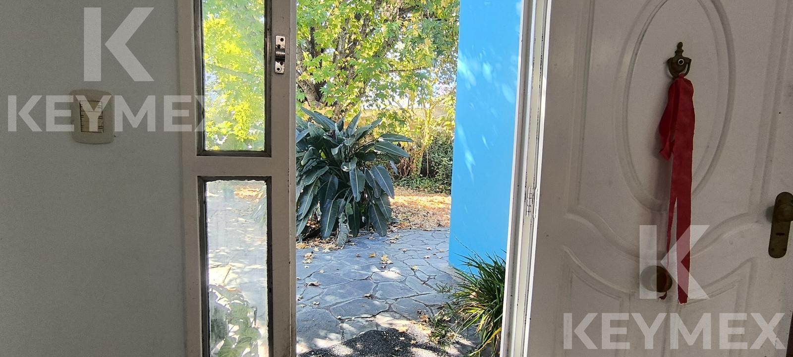 Vista lateral del inmueble — acceso entre patio y jardín
