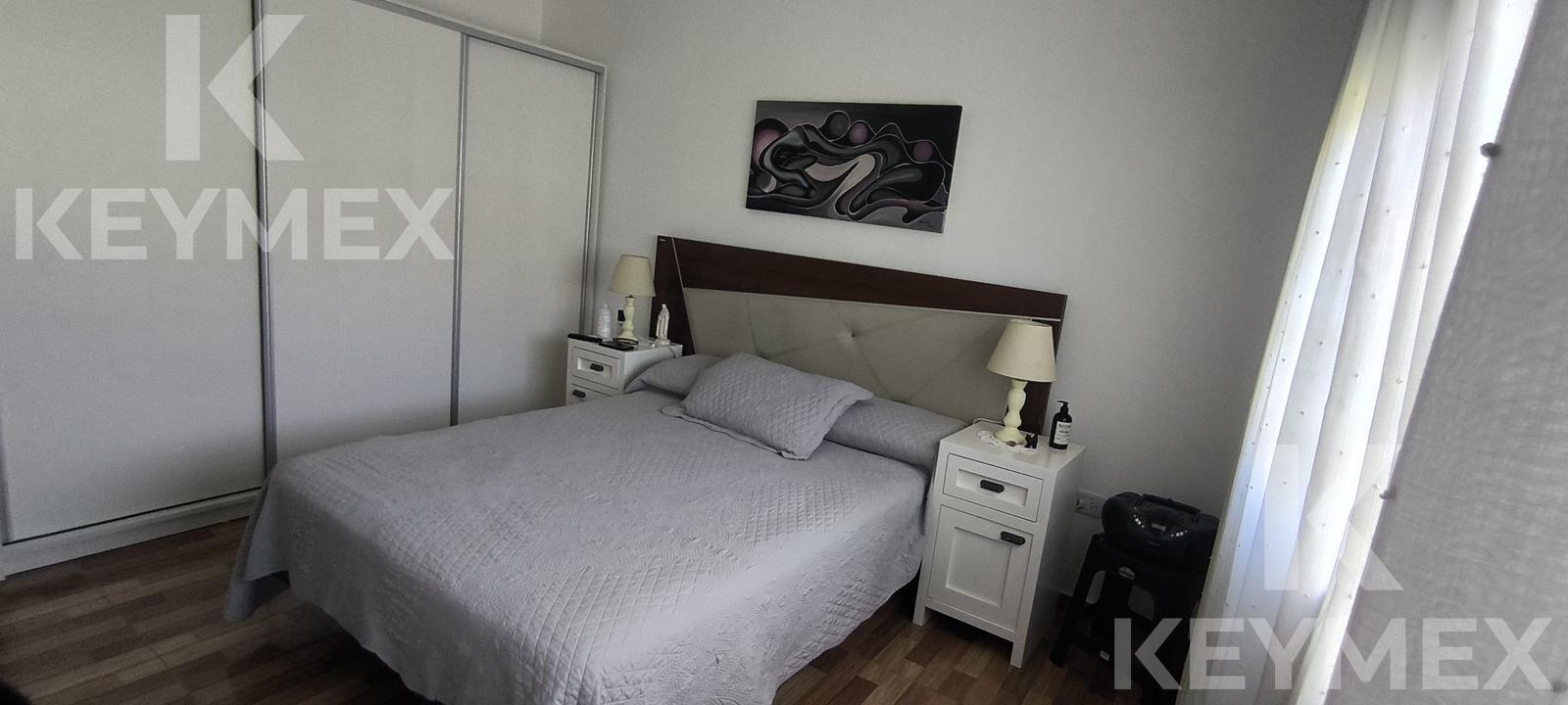 Dormitorio con cama doble y respaldo