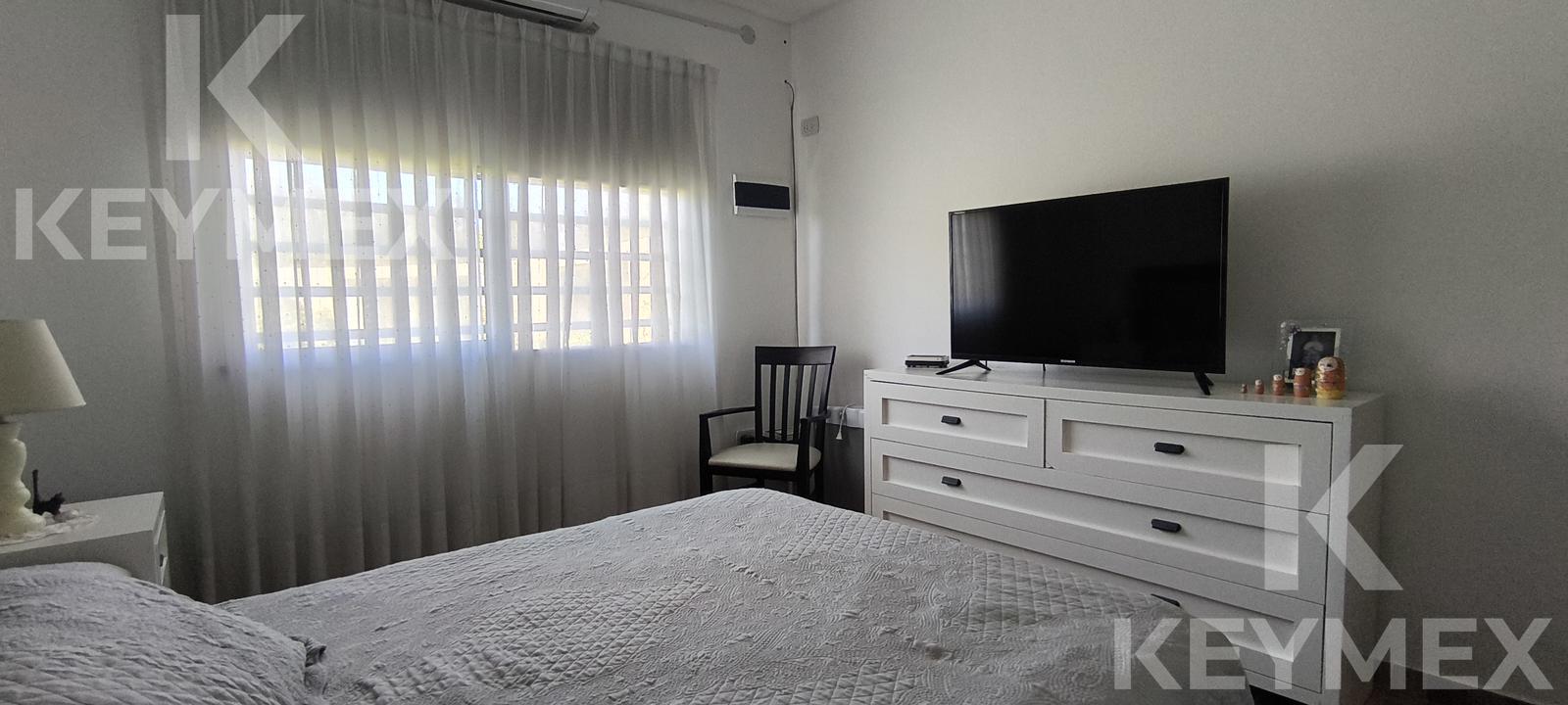 Dormitorio con ventana y cortinas