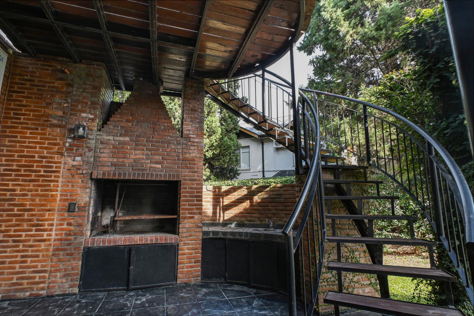 Galeria con parrilla y escaleras hacia terraza