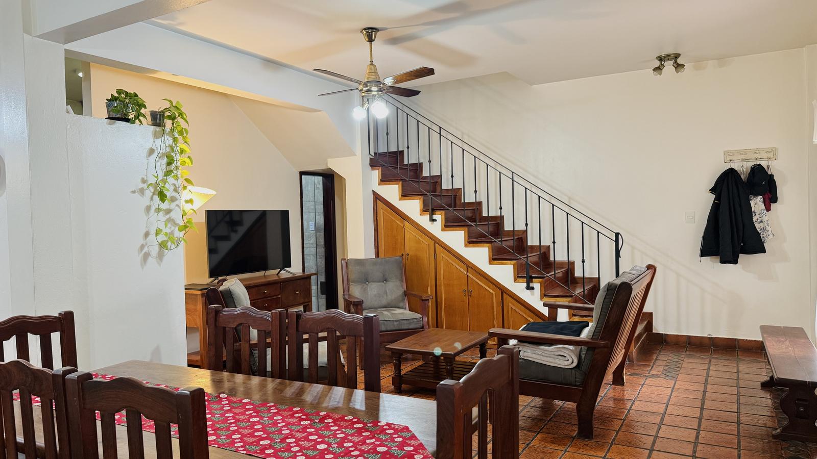 living, escalera y acceso a baño completo