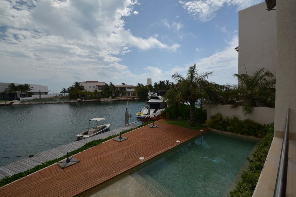 Residencia con alberca frente a canal